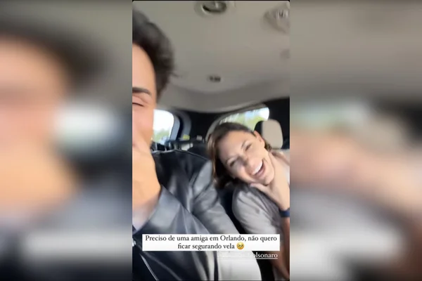 frame de vídeo com duas pessoas, a primeira cortada à esquerda, rindo