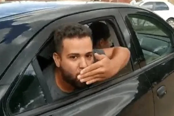 De dentro de um veículo preto ele manda beijos