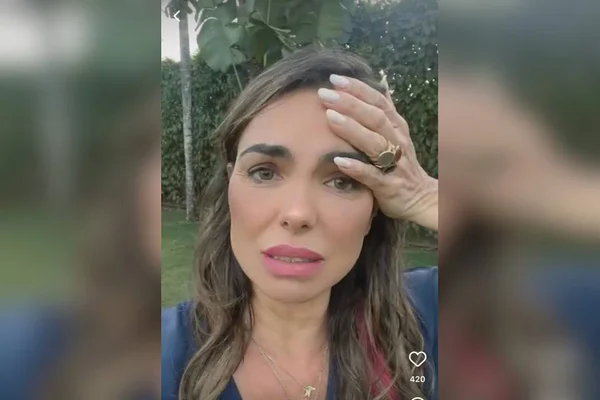 Fotografia colorida de rosto de mulher com mão esquerda na testa