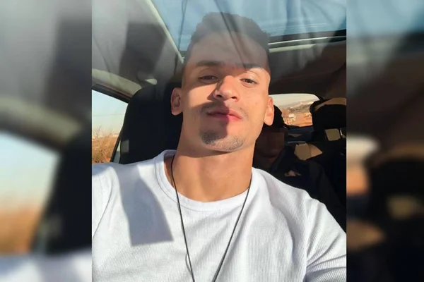 Homem branco de cabelos curtos senta dentro de carro. Ele veste camisa branca