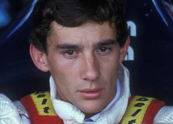 Considerado o maior piloto de Fórmula 1 do Brasil, Ayrton Senna hoje comemoraria 62 anos. Na foto ele olha sério para frente em uniforme de corrida - Metrópoles