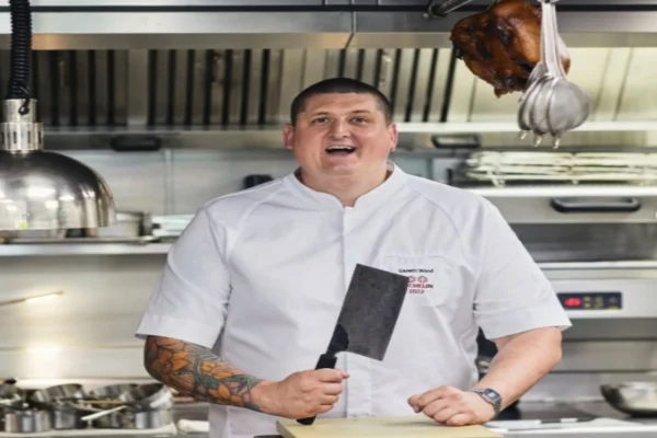 Chef de cozinha vestido de dólmã e com cutelo na mão