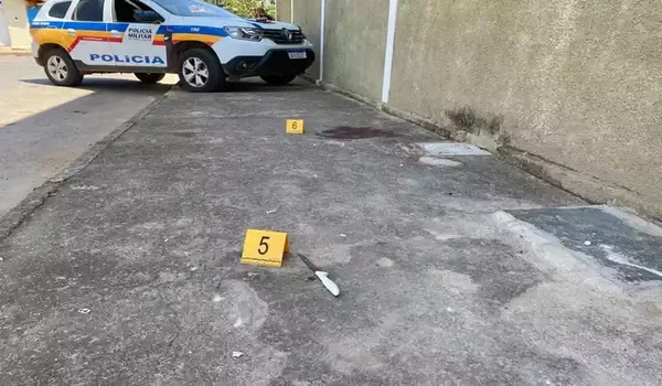 Fotografia da cena do crime. Facas no chão e sangue, em um beco