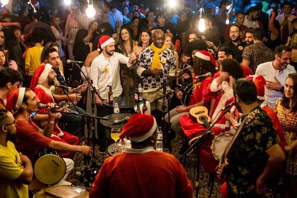 roda de samba com pessoas com gorro de papai noel - metrópoles