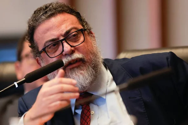 homem de barba branca com mão no queixo