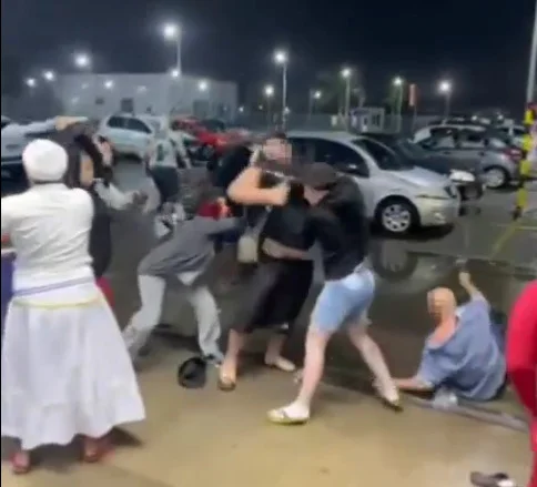 No centro da imagem, um homem é agredido por dois outros homens; à esquerda, uma mulher com vestimenta religiosa branca; à direita, um homem careca caido no meio fio - Metrópoles