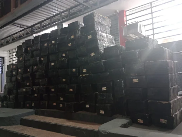 Fardos pretos empilhados em galpão, próximos à janela - Metrópoles
