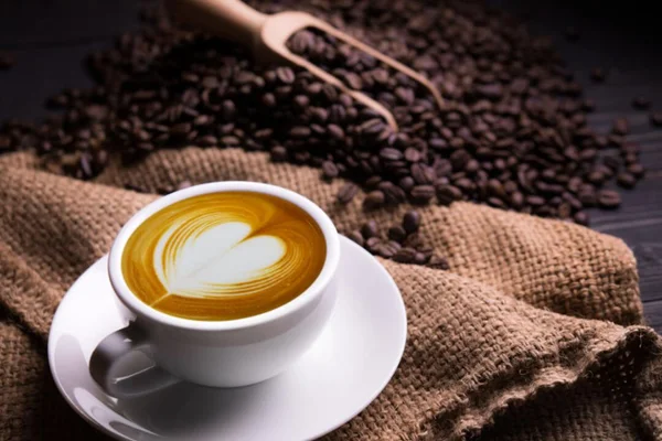 Café na xicara e com alguns grãos