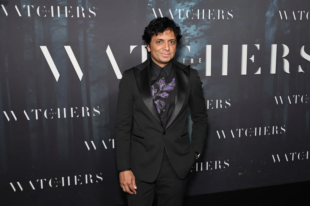 Imagem colorida de M. Night Shyamalan usando terno, em evento - Metrópoles