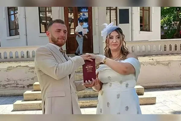 Imagem colorida, casal segurando bebida durante festa de casamento - Metrópoles