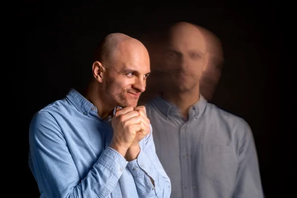 Foto colorida com fundo preto, de um homem vestido com blusa azul, tirada de dois ângulos - Metrópoles.