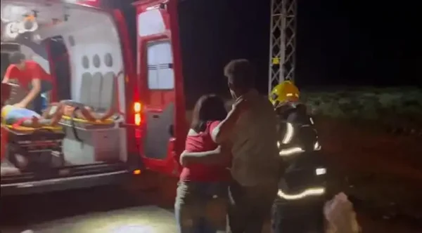 Imagem colorida de mulher sendo socorrida por bombeiros