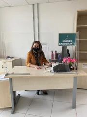Servidora da DPDF em sua estação de trabalha com adoção de medidas de distanciamento social Servidora da DPDF em sua estação de trabalha com adoção de medidas de distanciamento social