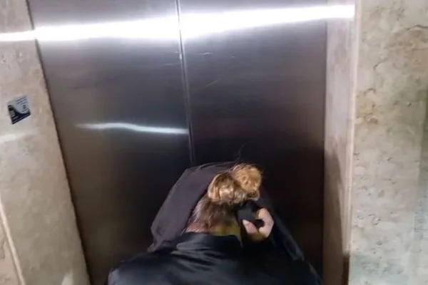 Mulher cobre a cabeça com blusa na chegada à delegacia