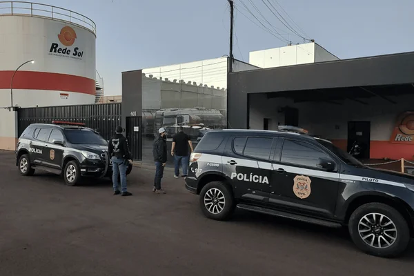 Imagem colorida de policiais cumprindo mandado de prisão em operação contra ladrões de combustível; sete foram presos - Metrópoles