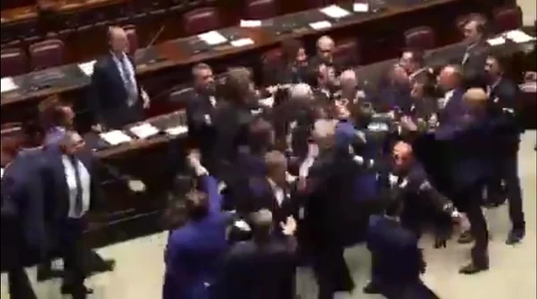 Imagem colorida mostra deputados brigando no Parlamento da Itália- Metrópoles