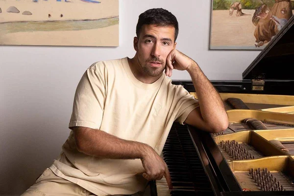 Foto colorida de Julio Secchin com piano - Metrópoles
