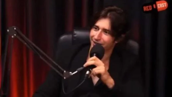 Foto colorida de influenciador dando declaração a podcast