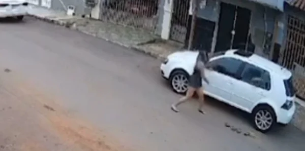 mulher atirando pedra em carro