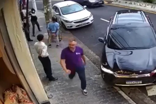 Imagem colorida de homem apontando arma. Metrópoles