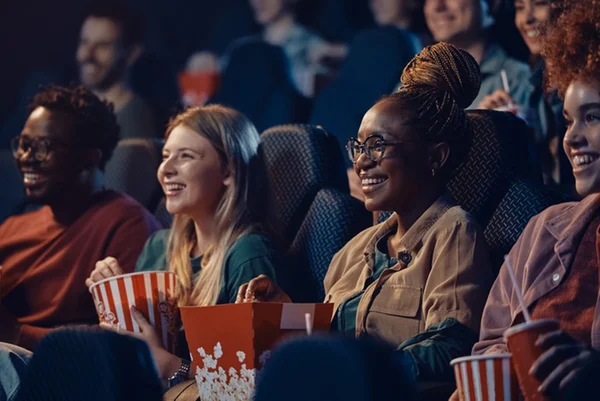 Foto de mulheres comendo pipoca em sala de cinema - Metrópoles