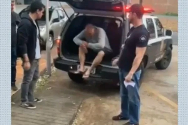 Imagem colorida de homem saindo da viatura da Polícia Civil - Metrópoles