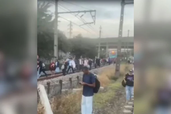 Imagens coloridas mostram pessoas andando por trilhos de trem