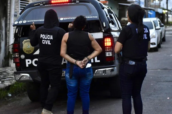 Imagem colorida, mulher sendo presa e conduzida para uma viatura - Metrópoles