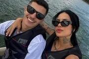 Tati Zaki and Mateus Oliveira pose while riding jet skis