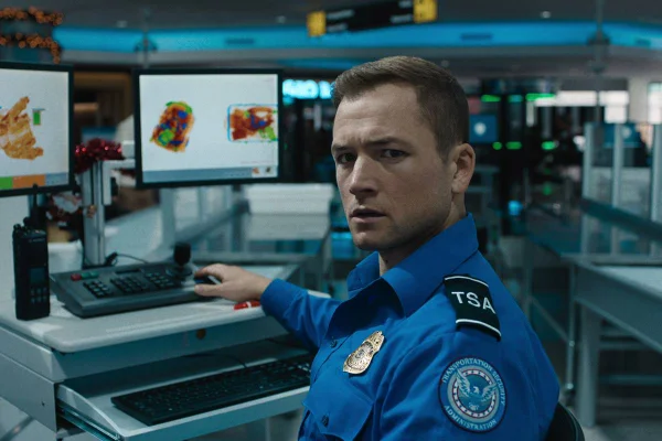 Foto colorida de Taron Egerton como Ethan Kopek em Bagagem de Risco - Metrópoles