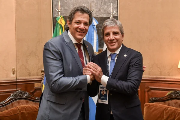 Haddad e Luis Caputo de mãos dadas