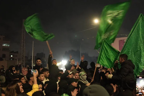 foto colorida de varias pessoas juntas balançando bandeiras verdes - metrópoles