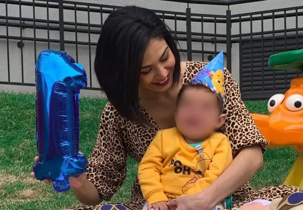 Imagem colorida de mulher com o filho no colo - Metrópoles