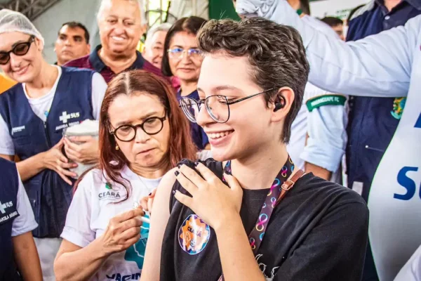 Foto colorida de jovem recebendo vacina - Metrópoles
