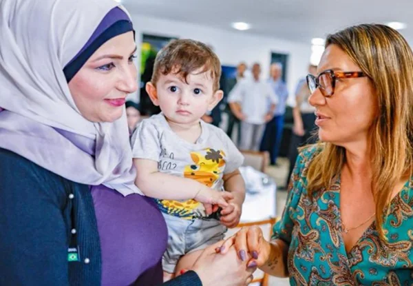 Foto colorida de Janja ao lado de brasileira e criança de Gaza repatriados - Metrópoles