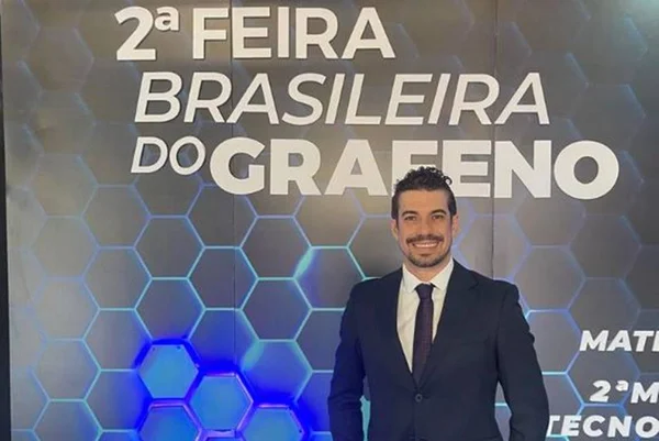 Homem branco de terno posicionado à frente da logo da 2ª Feira Brasileira do Grafeno - Metrópoles