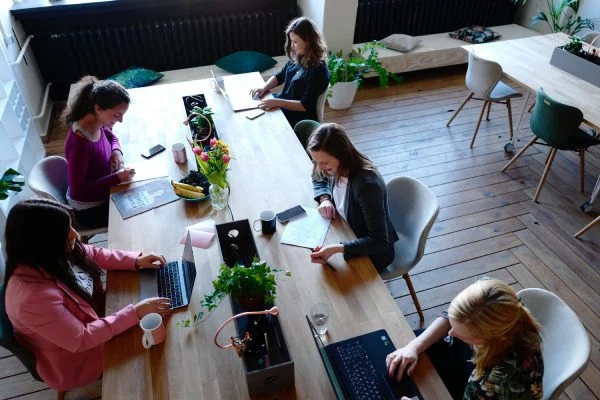 Mulheres reunidas em uma mesa trabalhando