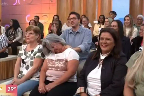 Na imagem colorida, pessoas estão sentadas em plateia e sorriem - Metrópoles