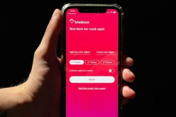 Foto colorida de uma mão segurando celular; na tela, o aplicativo do banco Bradesco - Metrópoles
