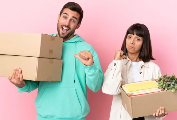 Homem e mulher segurando caixa de papelão nas mãos