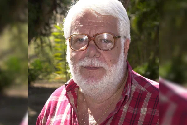 foto colorida de homem branco de barba branca e oculos de grau vestindo blusa xadrez vermelha - metrópoles