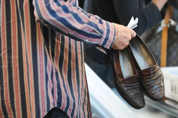 Passageiro retirando sapatos em revista de aeroportos dos EUA - Metrópoles
