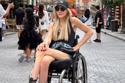 Andrea Schwarz posa de óculos escuros e boné durante viagem