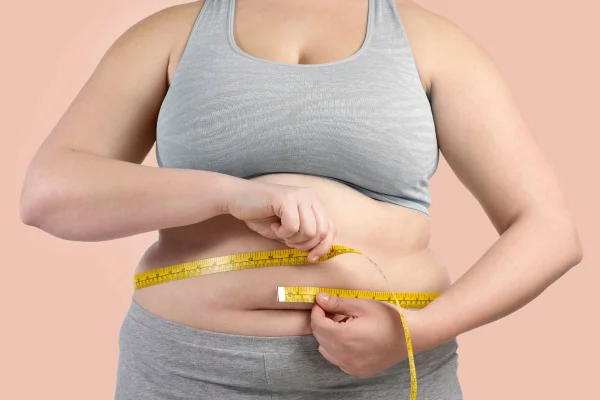 foto colorida mulher medindo a cintura e gordura abdominal