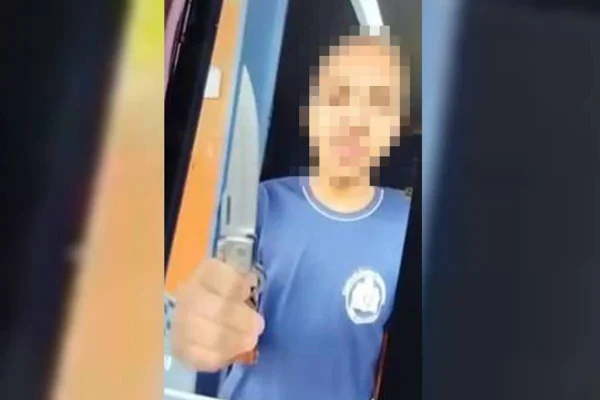 aluno de escola segurando faca