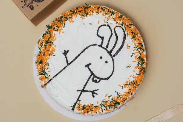 Bolo BentoNoffees, uma mistura do estilo bento com o sabor banoffee. Na foto, o bolo tem cobertura branca com desenho de coelho e confeitos coloridos - Metrópoles