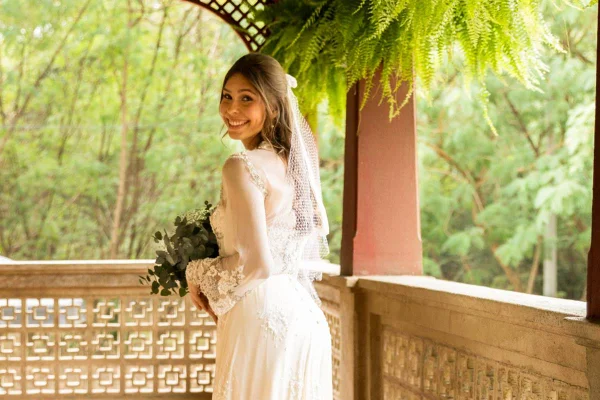foto colorida de mulher vestida de noiva sorrindo de costas - metrópoles