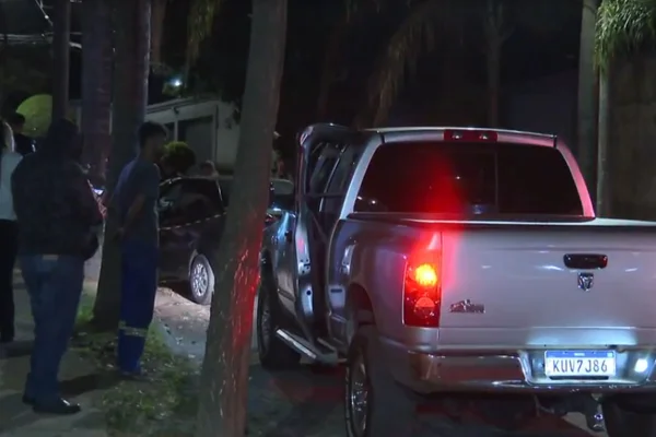 Caminhonete cinza com os faróis acesos comerciante homem prensado