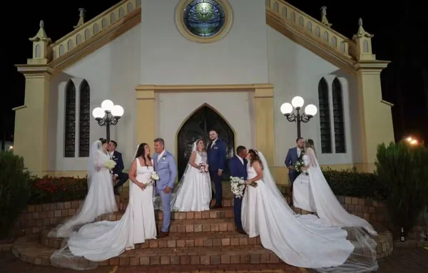 cinco casais de noivos em frente a uma igreja no interior de SP