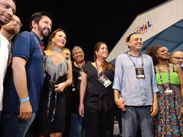 Imagem colorida mostra o prefeito Ricardo Nunes, de camisa azul, ao lado da mulher e outros convidados no Sambódromo do Anhembi, em São Paulo - Metrópoles